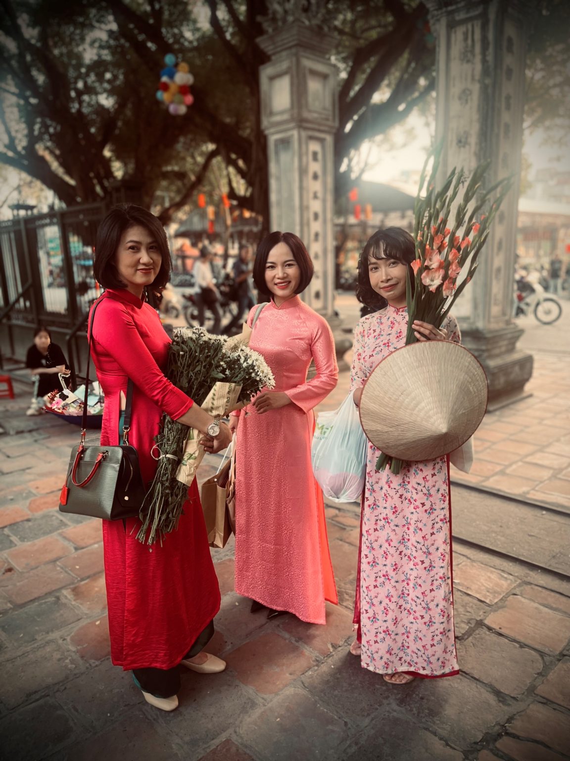 £ giovani ragazze in vestito tipico ad Hanoi fuori dal tempio della letteratura
